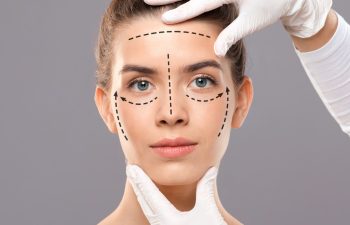 plastic surgeon making marks on beautiful lady face