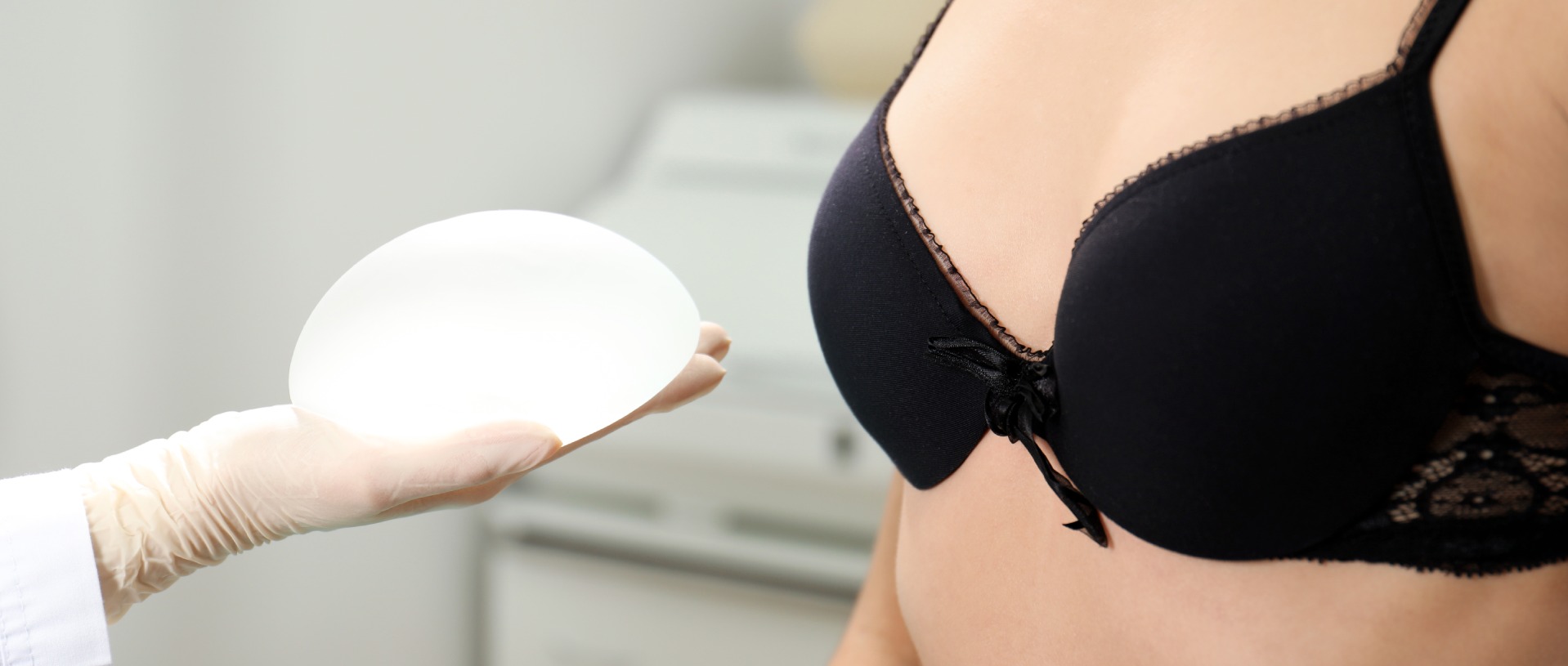 doctor showing silicone implant for breast augmentation to patient