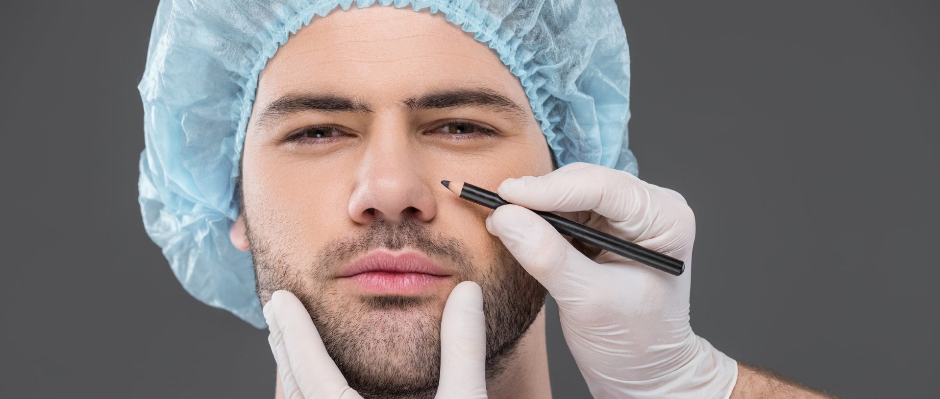 doctor drawing lines for facelifting on handsome man