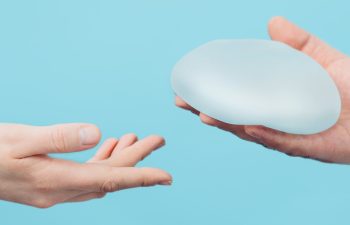 plastic surgeon holding breast silicone implant