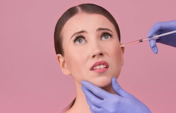 doctor makes cosmetic injection on beautiful woman face