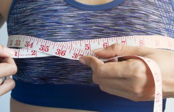 woman measuring breasts, breast reduction