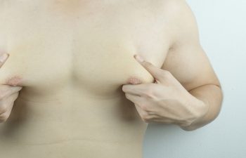 man holding men boobs on white background