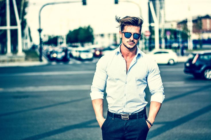 Confident handsome businessman walking across a city street.