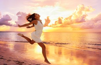 mujer feliz en la playa, puesta de sol