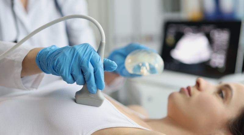 A doctor examining woman's breasts using ultrasound.