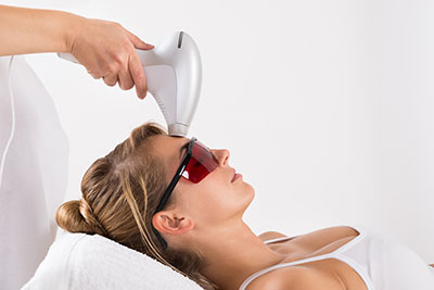 Closeup of young woman undergoing laser treatment at salon