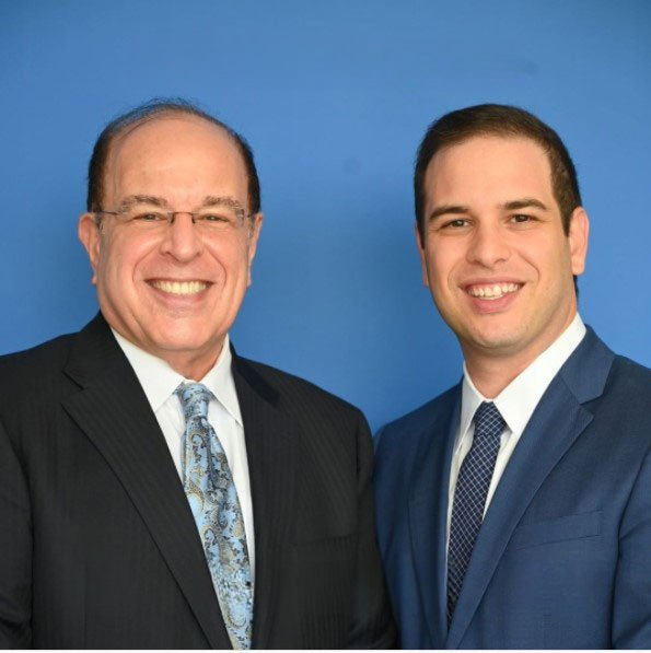 Dr. David Azouz y Dr. Solomon Azouz, sonriendo y de pie juntos