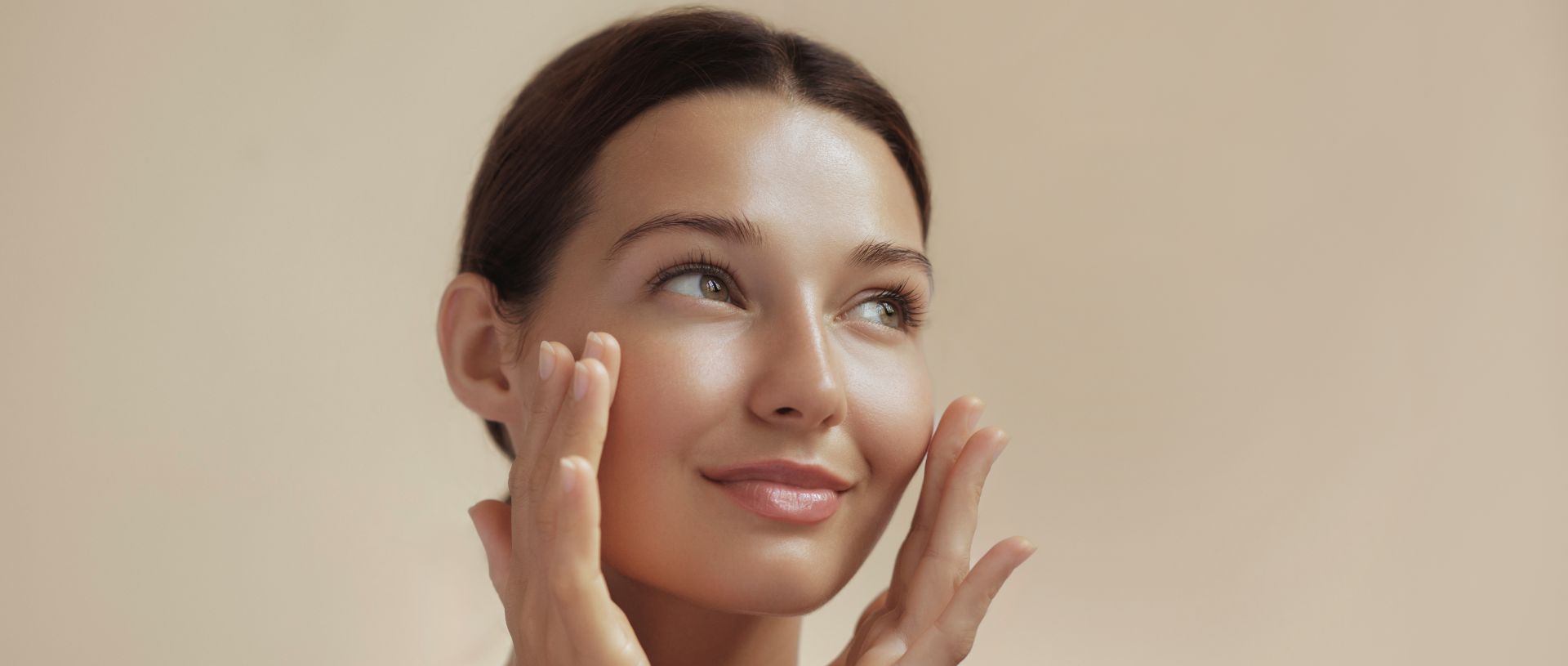 Woman after facial rejuvenation with fat transfer touching her cheeks