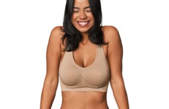 Young Filipino woman in light wear laughs and closes eyes.