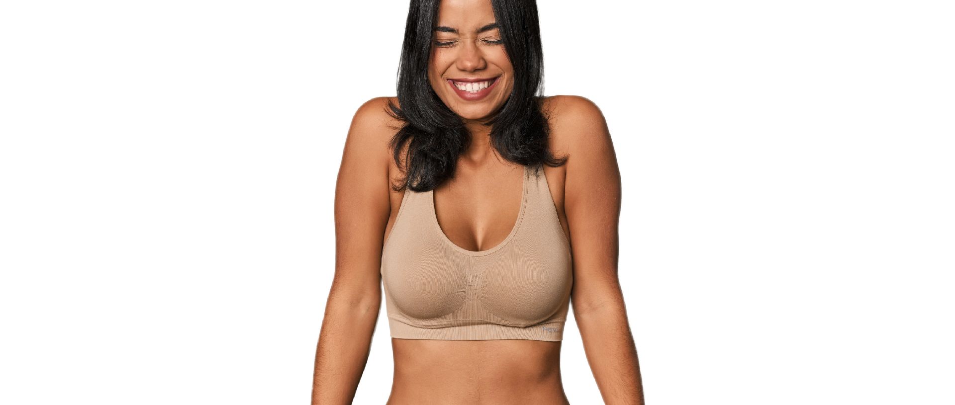 Young Filipino woman in light wear laughs and closes eyes.