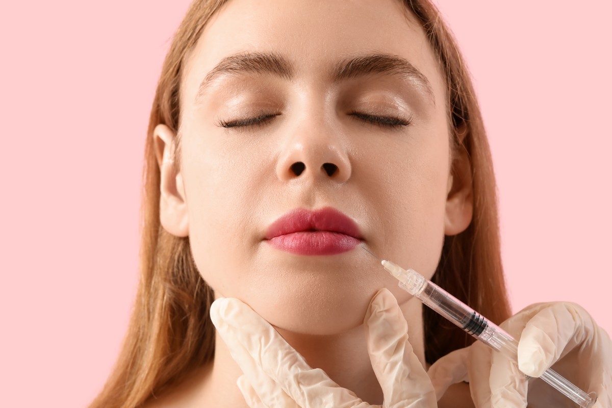 Young woman receiving filler injection in face
